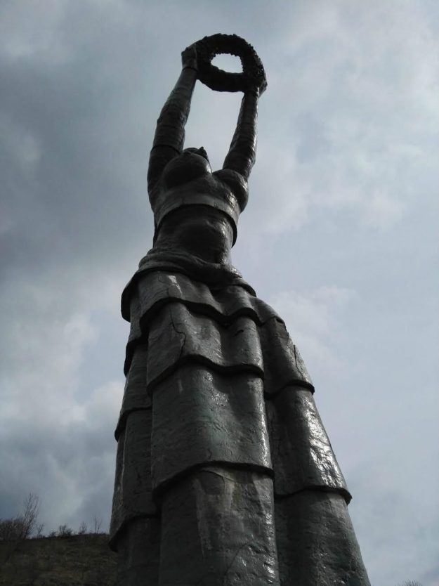 Foto: Monumentul „Danubia” de la intrarea în municipiul Orșova (județul Mehedinți), operă monumentală de 6,5 metri realizată în 1996 de sculptorul Patriciu Mateescu. Lucrarea, dedicată memoriei miilor de români care au încercat să evadeze din regimul comunist înotând peste Dunăre, prezintă fisuri structurale avansate și degradări ale plăcilor ceramice, pe fondul lipsei de conservare din partea administrației locale.